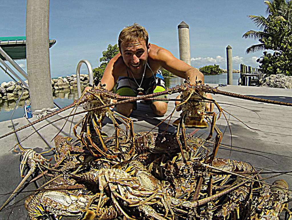 captain nick labadie poses with a pile of lobster caught while free diving in the Florida keys.