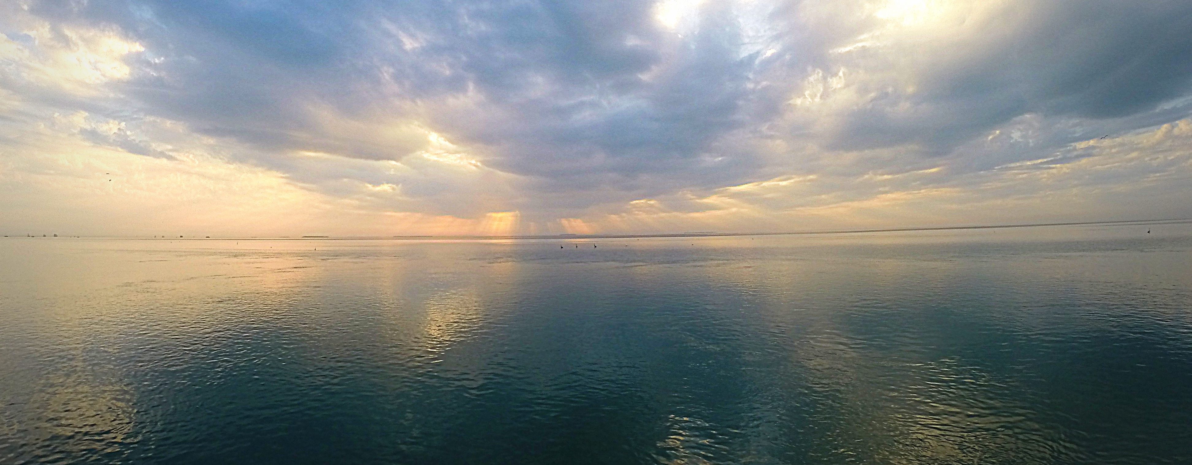 a colorful cloudy afternoon sky meets with the calm backcountry water off of key west